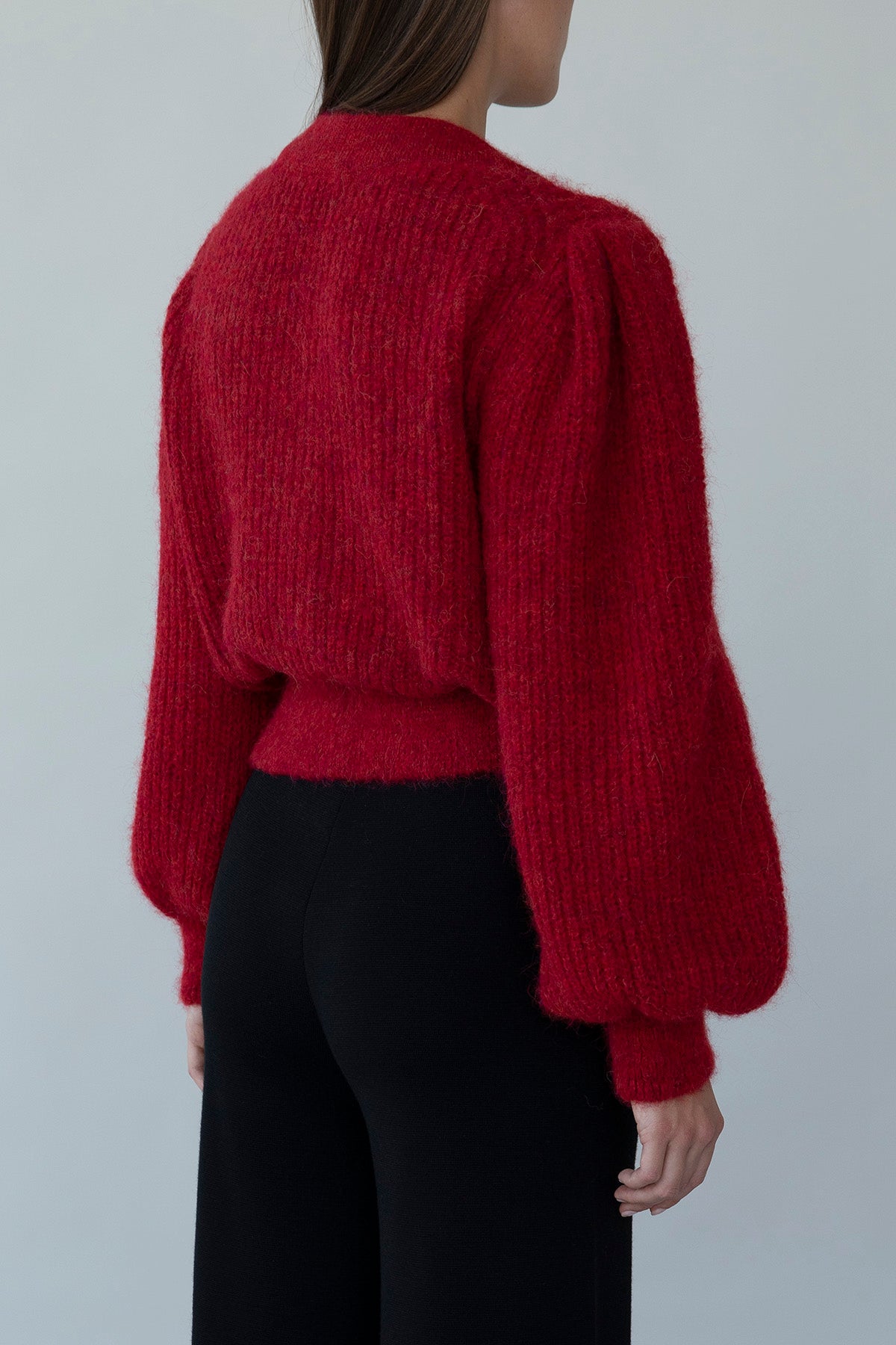 Side view of crimson red Meredith Peck collaboration cardigan, showing relaxed, structured fit and dramatic sleeves.