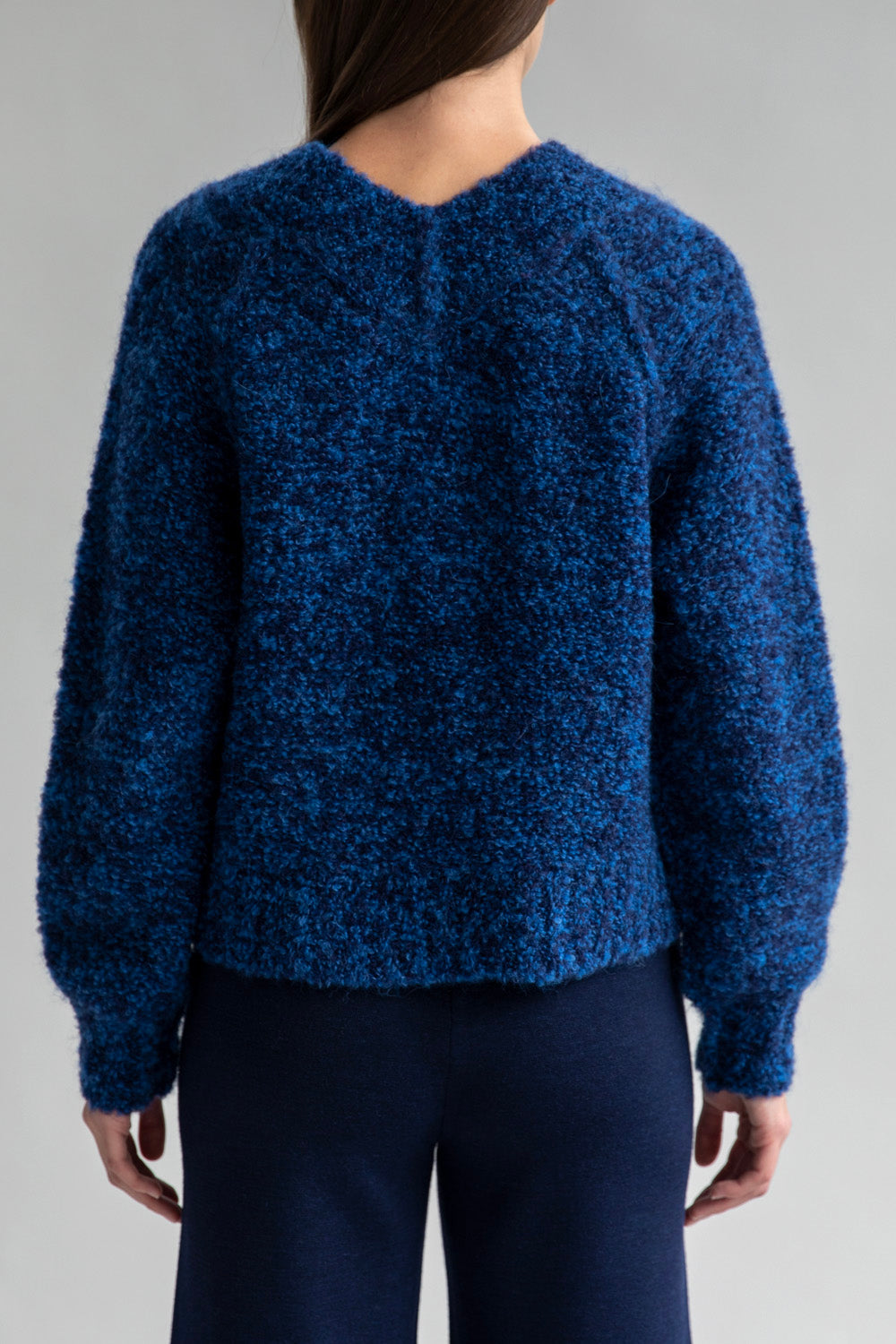 Full back view of a model wearing a Sky Navy alpaca-nylon blend sweater. Paired with matching wide leg trousers in navy.