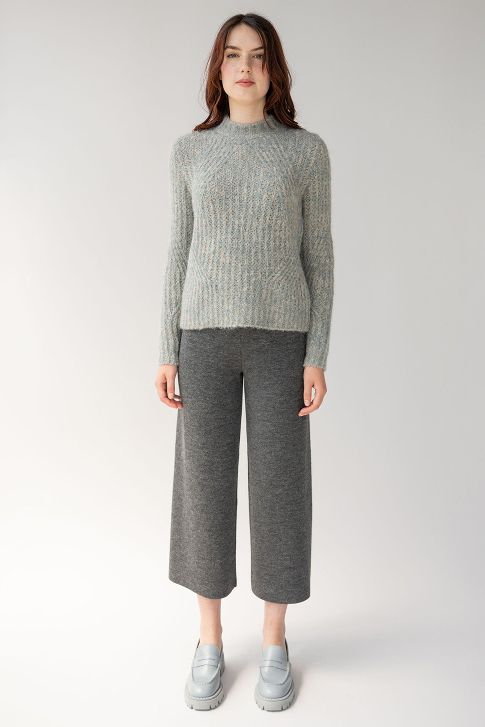 Head to toe grey outfit top is grey sweater bottoms are wide leg trousers made from responsibly sourced alpaca