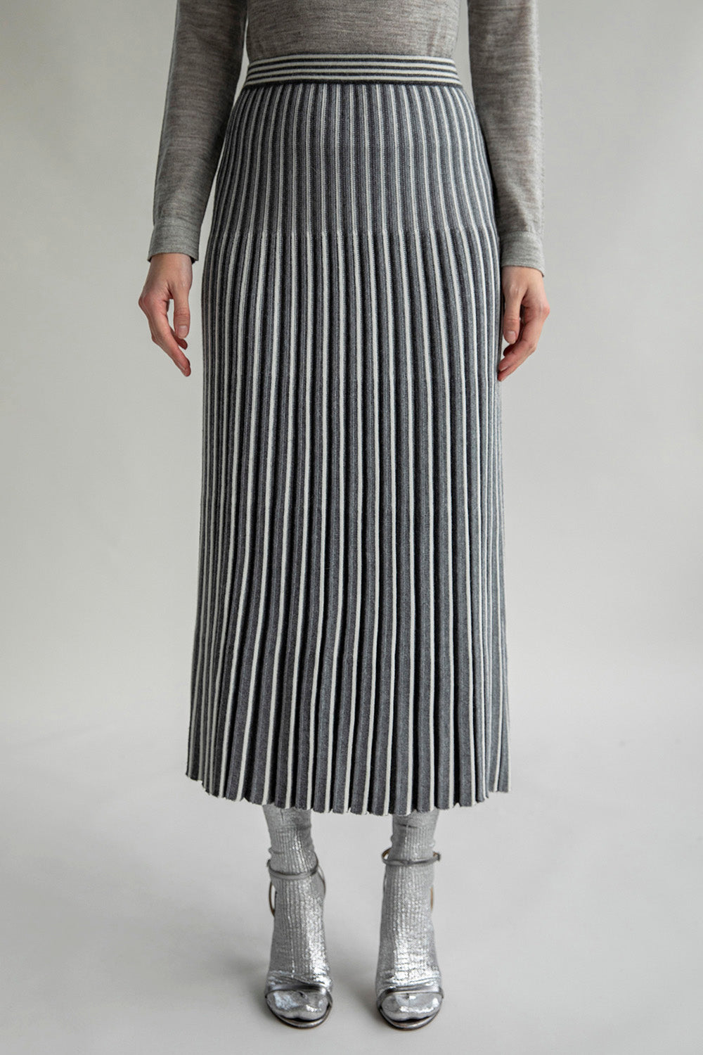 Front view of the Adeline Skirt, showcasing a pleated design with contrasting stripes and a graphic waistband. Made from a blend of baby alpaca, silk, and nylon.