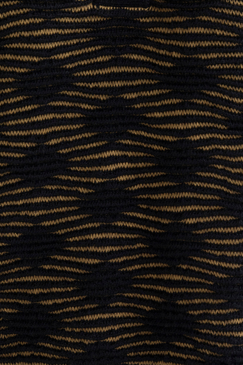 Close-up of the Amelie Polo highlighting the monochromatic textured pattern in golden and black, made from a midweight baby alpaca blend.