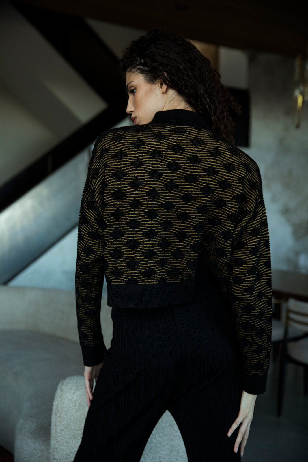 Back view of golden black polo showcasing clean lines and relaxed silhouette. 