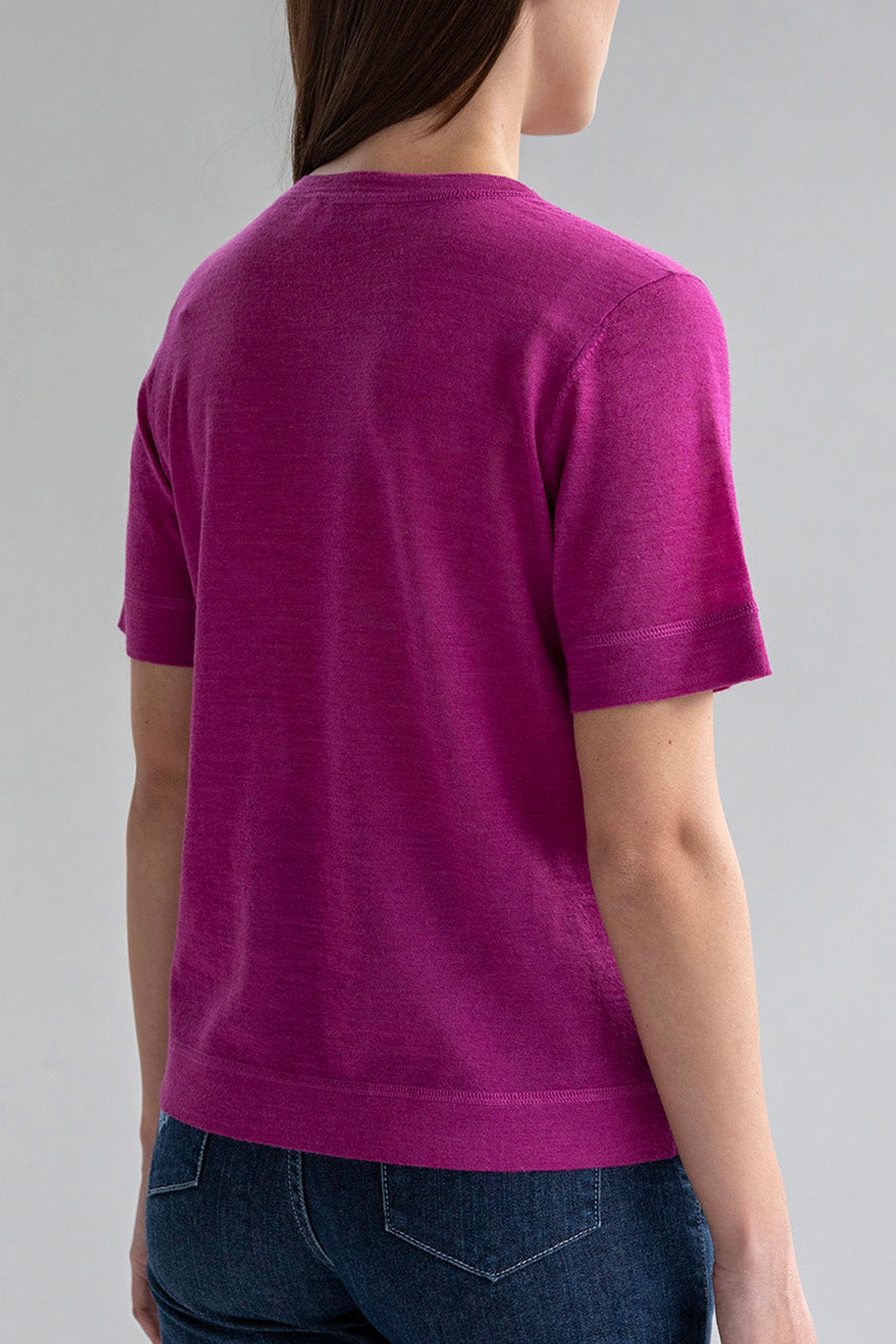 Back view of a woman wearing a fuchsia crew neck sweater tee.