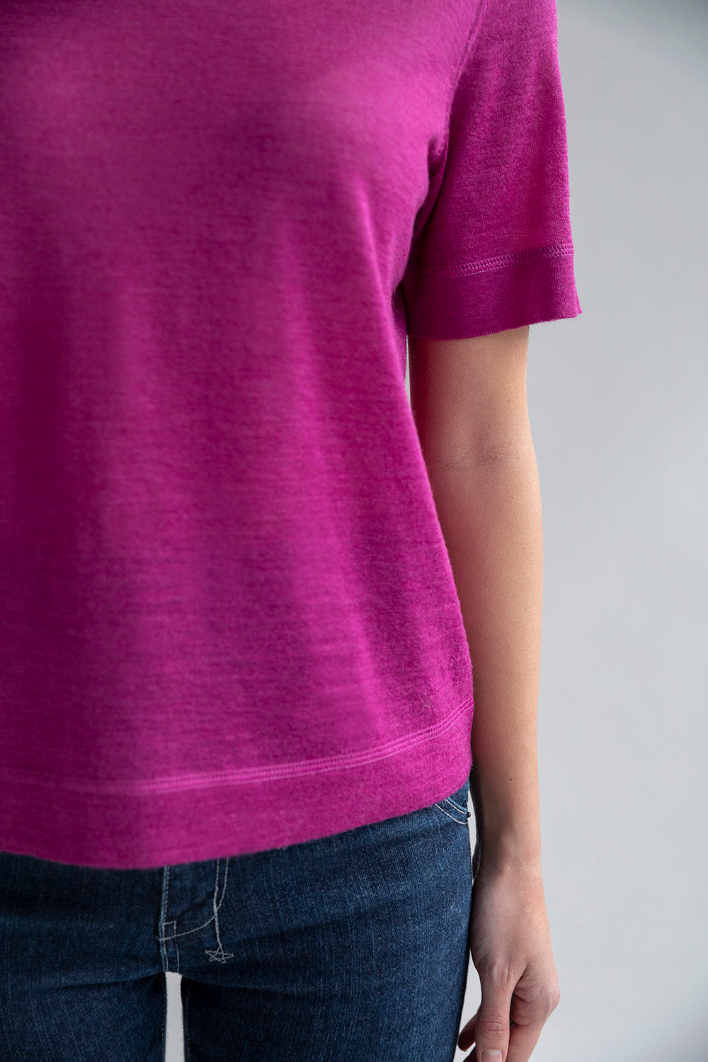 Close-up of self-yarn cover stitch details on the fuchsia crew neck sweater tee.