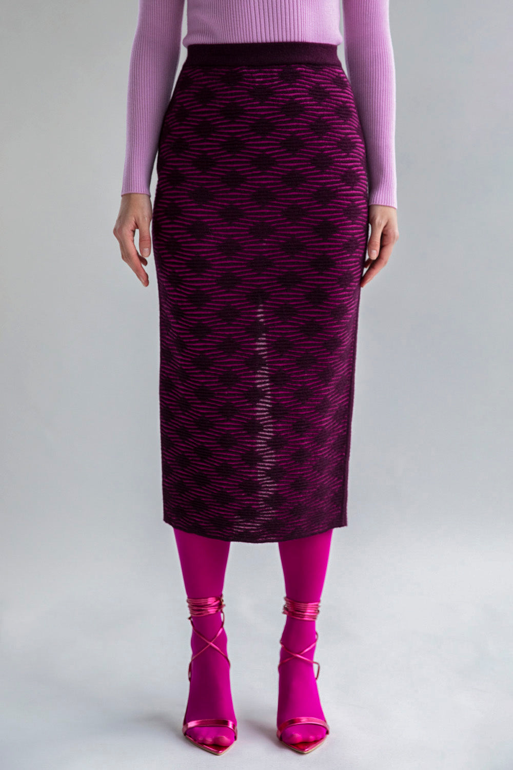 Fuchsia aubergine pencil skirt knitted in a subtle monochromatic pattern as seen on a model made from baby alpaca and cotton.