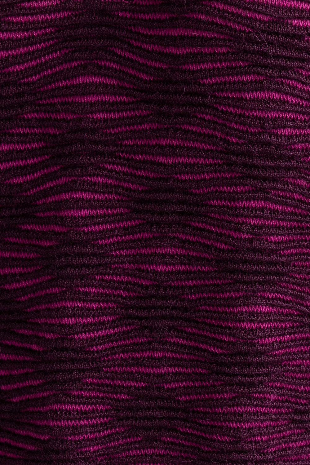 Close-up of the fuchsia aubergine Ines pencil skirt, highlighting the textured pattern in vibrant fuchsia and deep aubergine colors. Ethically made from baby alpaca and cotton.