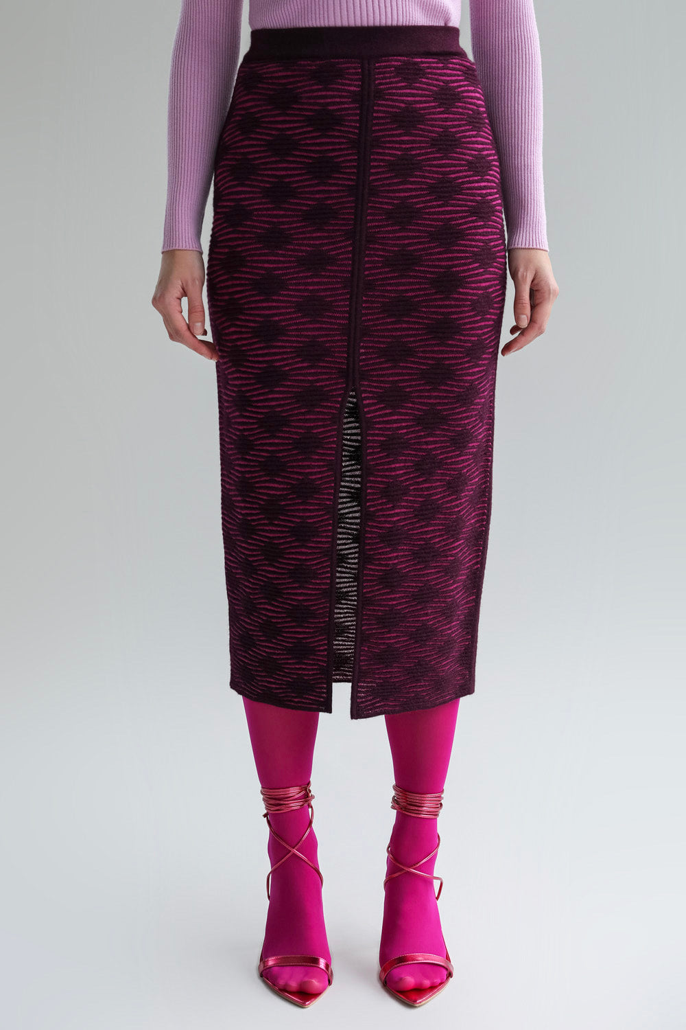 Front view of the fuchsia aubergine Ines pencil skirt, designed to be worn back to front, showing textured interest, an elegant slit, and a subtle pattern.