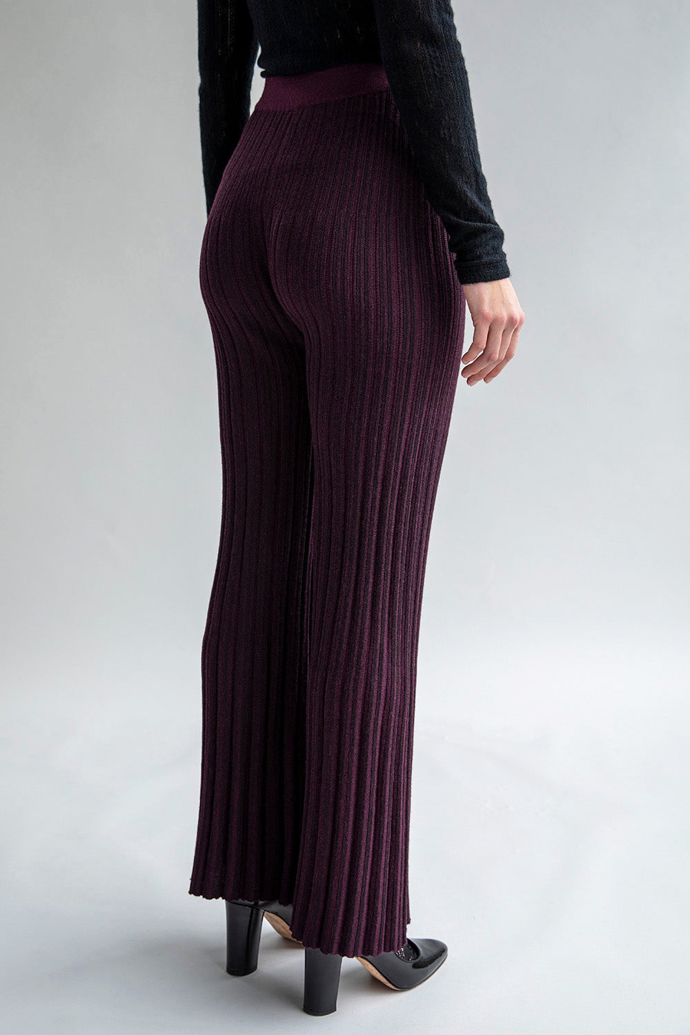 Side view of aubergine trousers featuring a matte and shiny stripe pattern.