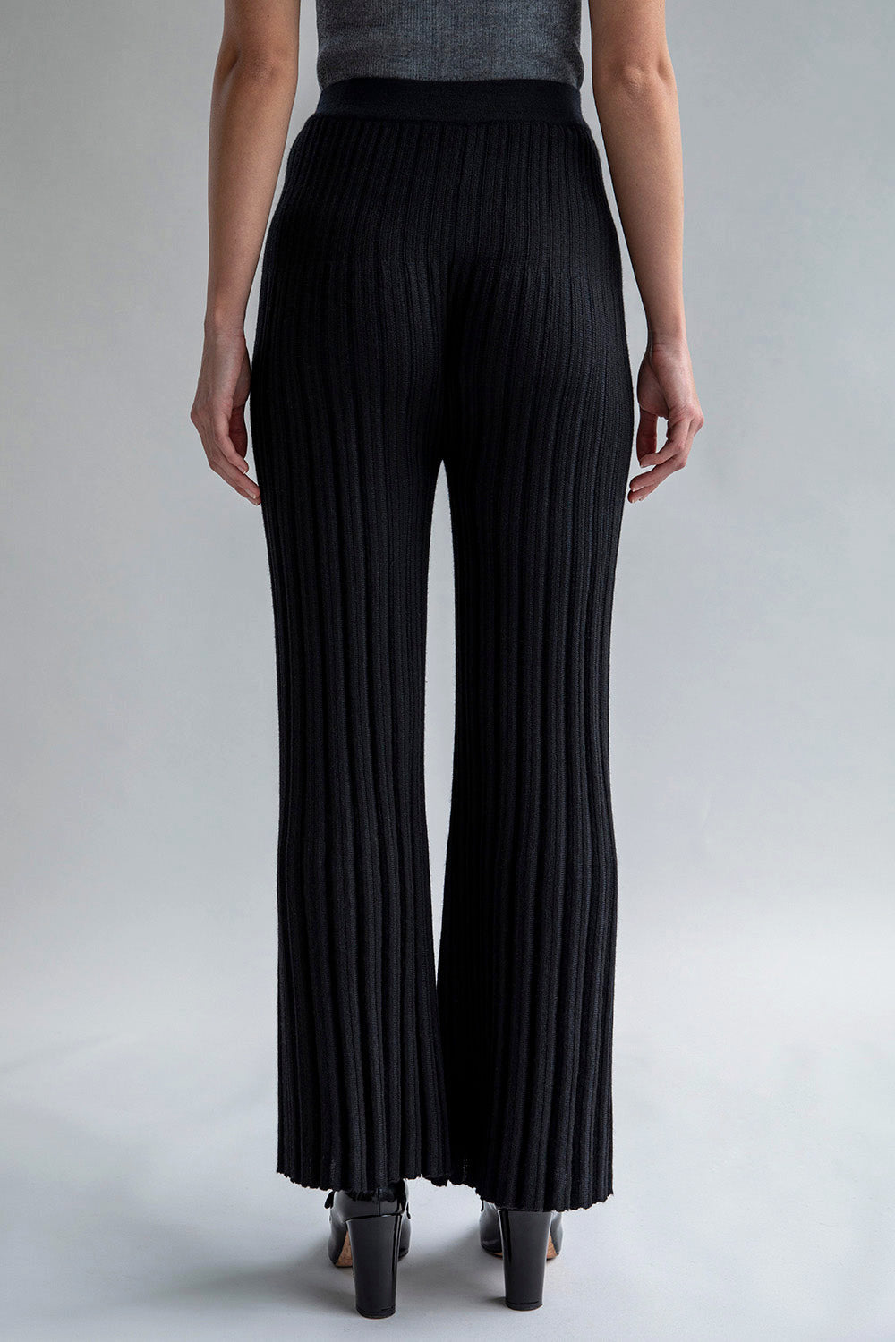 Full back view of a woman wearing Marcelle Trousers in black, showcasing the form-fitting design and mid-weight fabric.