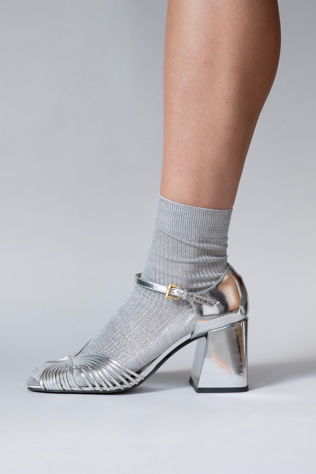 Close-up of the ribbed texture and metallic silver laminated sheen on the Lumine silk socks