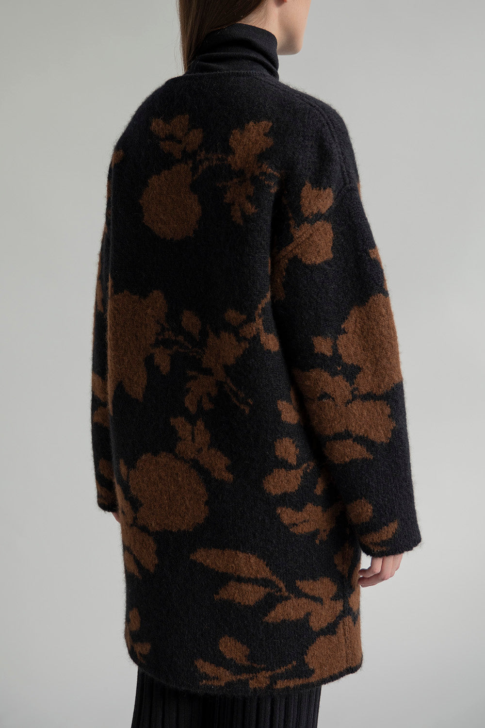 Back view of a model wearing a superfine alpaca reversible coat, showing its streamlined silhouette.